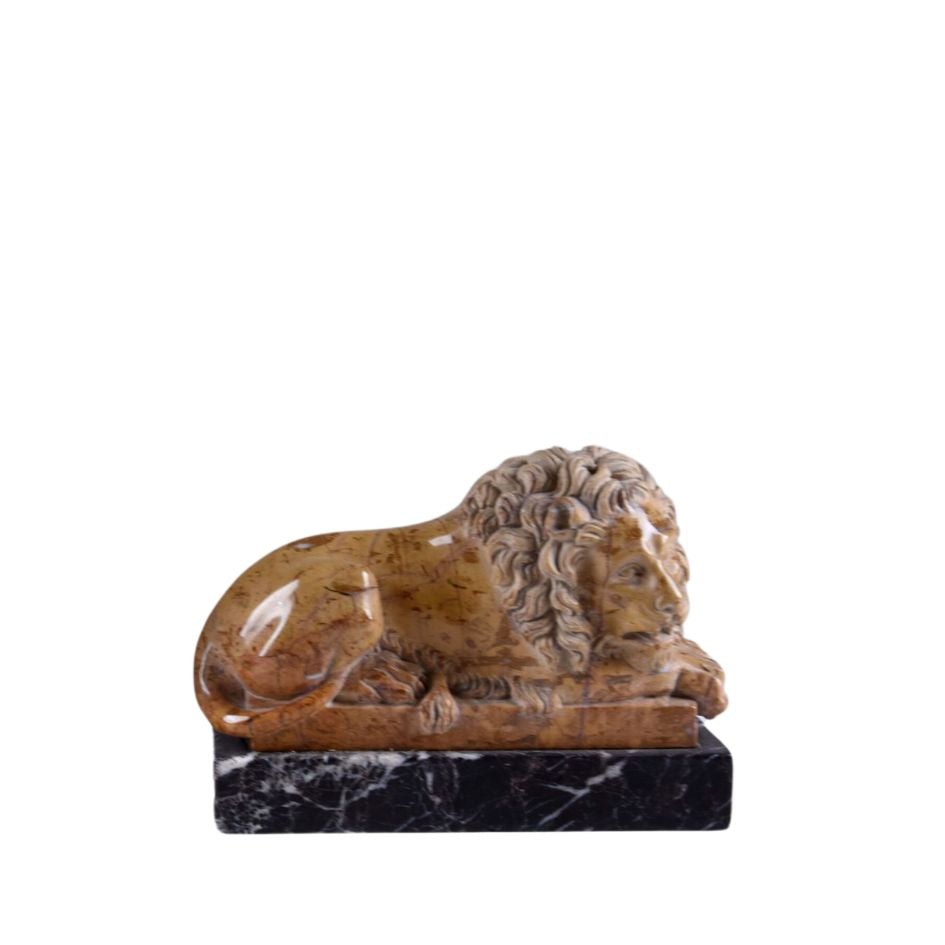 Marble sculpture of reclining lion in brown on black veined marble plinth, side view. Lion hand carved inspired by Antonio Canova