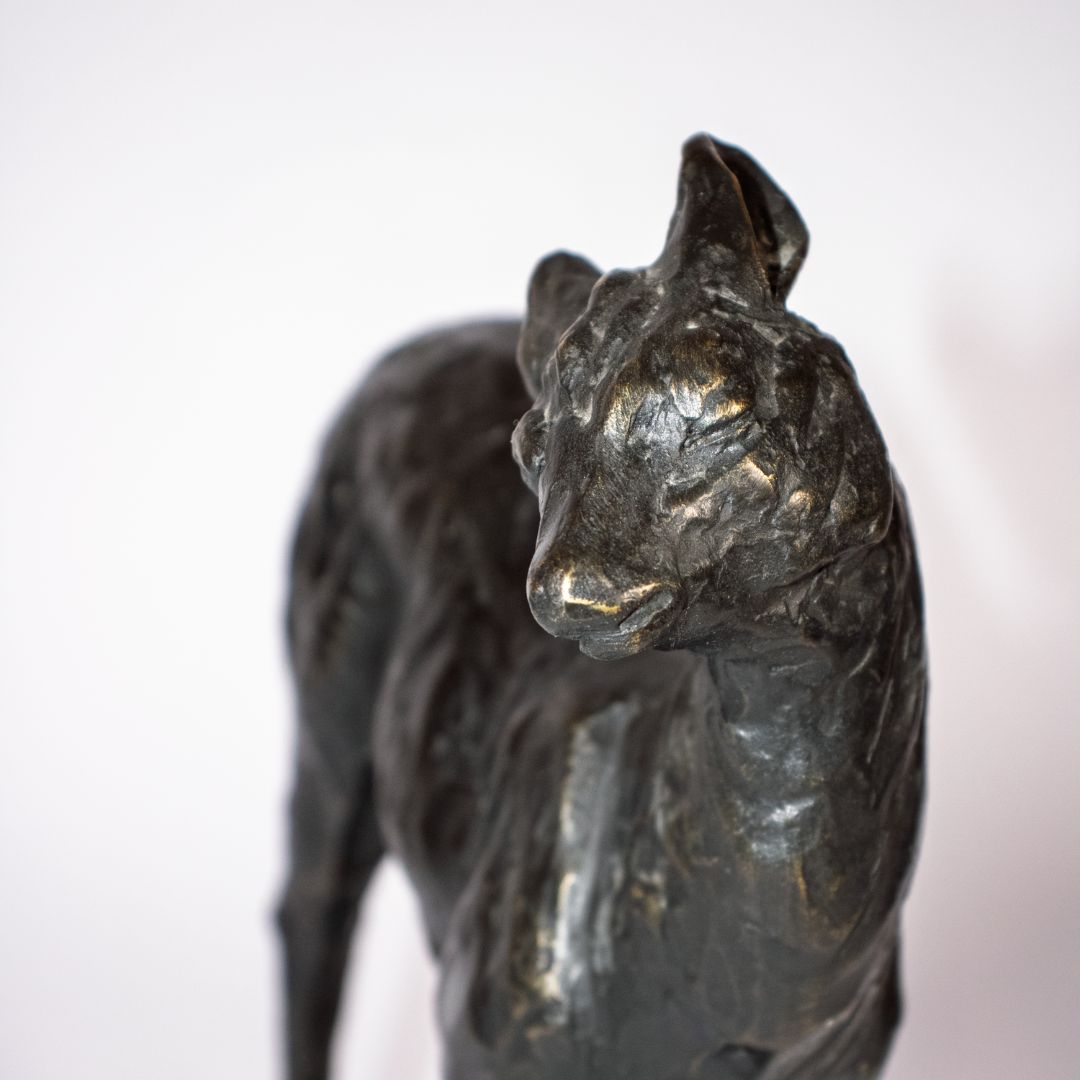 Close-up of head of bronze sculpture of a fawn deer with dark patina