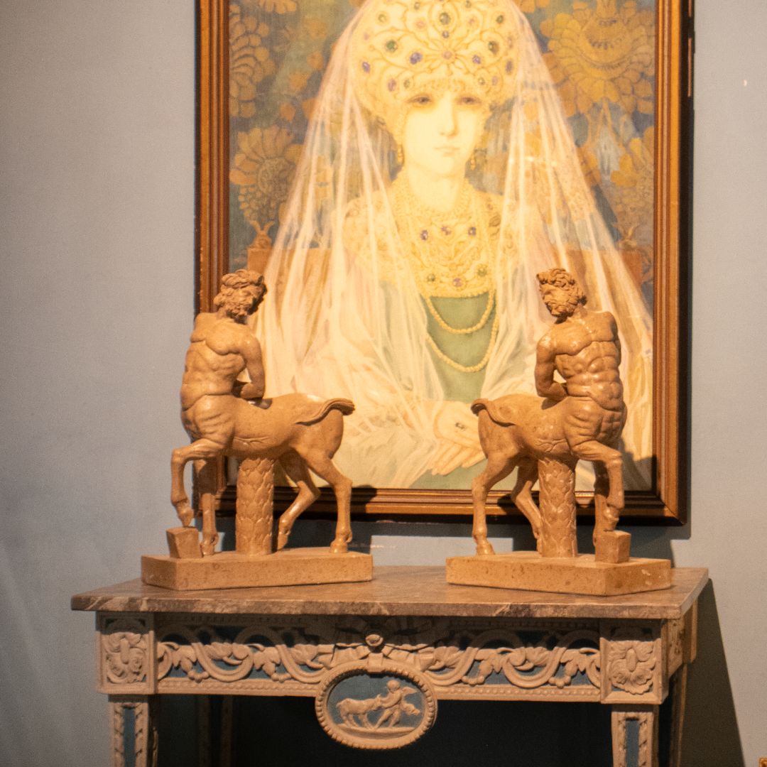 Pair of travertine marble sculptures depicting Borghese centaur figures on carved marble table with classical painting backdrop