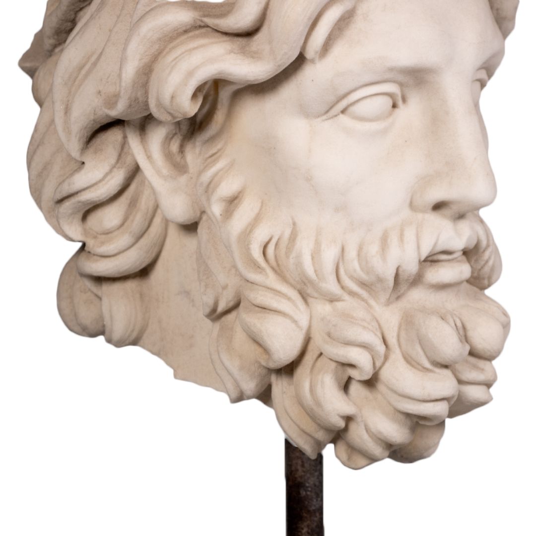 Sculpted marble head of Zeus bust with detailed beard and hair on black marble base