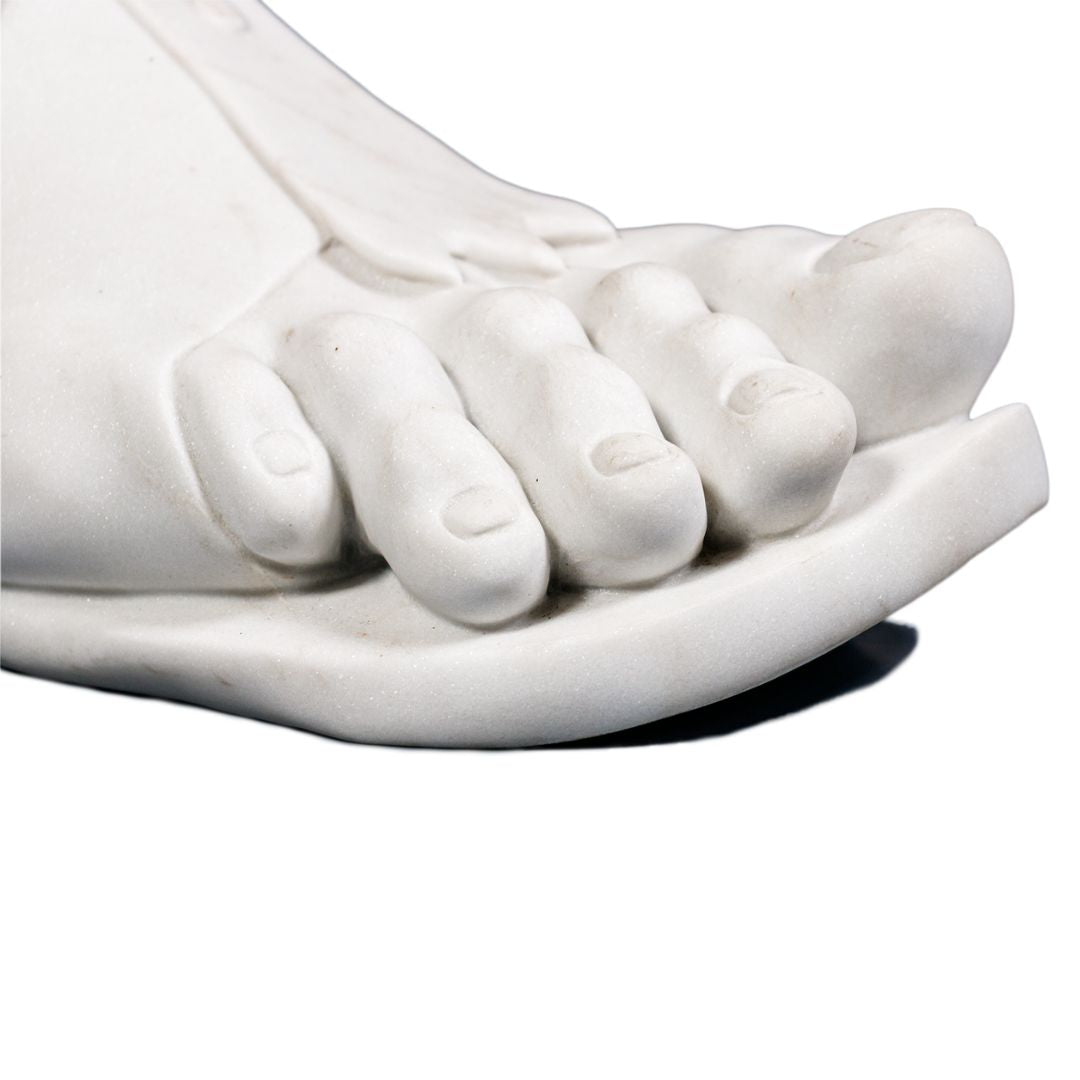 Macrodetail van de sandaalriem met ronde knop en strikknoop bij de enkel