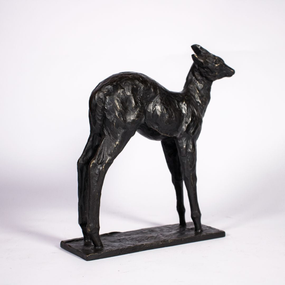 Right side view of bronze sculpture of a fawn deer with dark patina