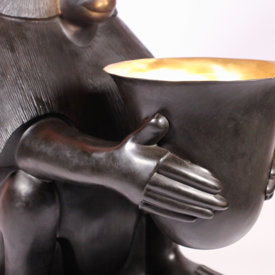 Détail de la lampe singe en bronze : mains du babouin entourant la coupe à l'intérieur doré