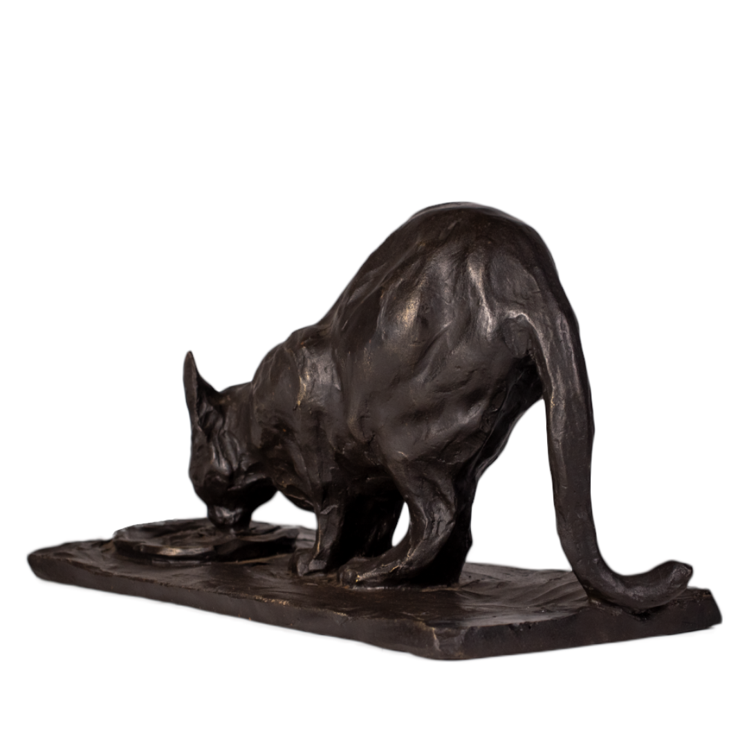 Gato de bronce bebiendo visto desde atrás en tres cuartos, cola larga apoyada en la base rectangular
